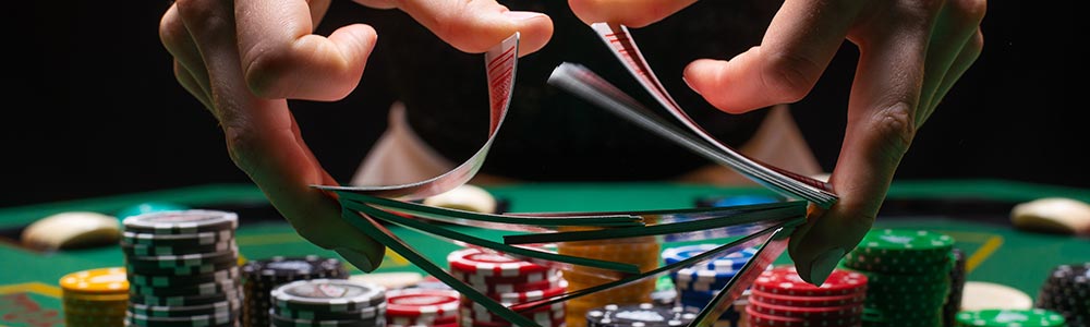 casino dealer shuffling the cards at a poker table