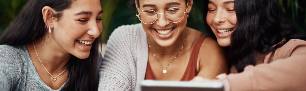 3 friends looking at a tablet 