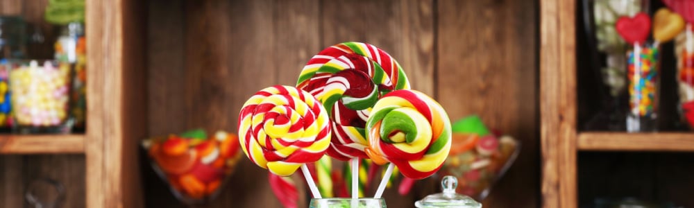 a display in a candy shop with colorful candy in jars and a lollipop display in a jar