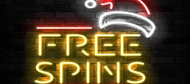 Neon sign reading free spins with a Santa hat above, on a dark brick wall