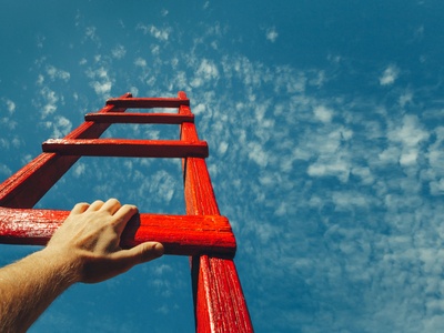 hands climbing a red ladder into the sky  