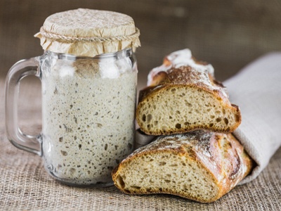 sourdough bread and starter in a jar on a table