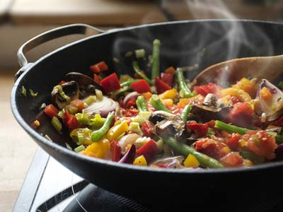 vegetables being sauteed in a wok